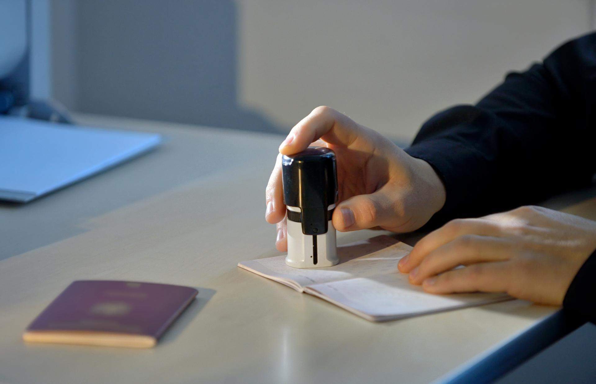 An unidentified person stamping a passport.